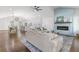 Bright living room showcasing an elegant fireplace, hardwood floors, and an open layout to the kitchen and dining area at 225 Valley Dr, Roswell, GA 30075