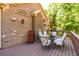 Deck with seating has outdoor dining and brick exterior with trees creating a relaxing space to unwind at 50 S Underwood Dr, Covington, GA 30016