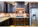 Gourmet kitchen featuring dark wood cabinetry, granite countertops, and a stylish mosaic backsplash at 50 S Underwood Dr, Covington, GA 30016