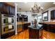 Well-appointed kitchen with double ovens, dark wood cabinetry, a central island, and hardwood floors at 50 S Underwood Dr, Covington, GA 30016