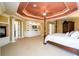 Large main bedroom featuring a tray ceiling, hardwood furniture, and access to private bath at 50 S Underwood Dr, Covington, GA 30016
