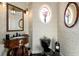 Elegant powder room featuring a carved vanity, decorative mirrors, and stylish wallpaper at 50 S Underwood Dr, Covington, GA 30016