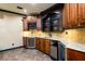 Beautiful wet bar with wine fridge, custom cabinets, stone backsplash and tile floor is great for entertaining at 50 S Underwood Dr, Covington, GA 30016