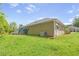 Spacious backyard with well-maintained lawn, mature trees and a view of the house's exterior at 8405 Military Way, Douglasville, GA 30134