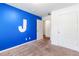 A bedroom with a blue accent wall and a view into another room, creating an open and spacious feel at 8405 Military Way, Douglasville, GA 30134