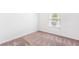 This bedroom features neutral carpeting, white walls, and a window providing ample natural light at 8405 Military Way, Douglasville, GA 30134