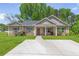 Charming single-story home featuring a welcoming front porch, well-manicured lawn, and a spacious concrete driveway at 8405 Military Way, Douglasville, GA 30134