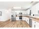 Bright kitchen featuring stainless steel appliances, white cabinets, granite counters, and stylish wood-look flooring at 8405 Military Way, Douglasville, GA 30134
