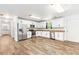 Spacious kitchen with stainless steel appliances, granite countertops, and white cabinets, complemented by wood flooring at 8405 Military Way, Douglasville, GA 30134