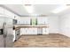 Modern kitchen features white cabinets, stainless steel appliances, granite counters, and beautiful wood-look floors at 8405 Military Way, Douglasville, GA 30134