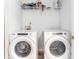 Bright laundry room featuring modern, front-load washing machine and dryer and shelf storage at 8405 Military Way, Douglasville, GA 30134