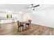 Open living space with modern wood floors, a dining table with chairs, and a kitchen with white cabinets at 8405 Military Way, Douglasville, GA 30134