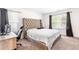 This bedroom features a plush, tufted headboard, neutral carpeting, and bright, natural light at 8405 Military Way, Douglasville, GA 30134