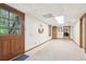 Finished basement hallway with carpet, wood trim, and a glass paneled door to the outside at 918 Guinevere Way, Lilburn, GA 30047