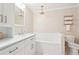 Bright bathroom features a white vanity with marble countertops, a soaking tub, and a decorative chandelier at 918 Guinevere Way, Lilburn, GA 30047