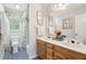 Bathroom featuring a double vanity with wooden cabinets, blue tile floor, and tub with shower at 918 Guinevere Way, Lilburn, GA 30047