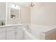 Bright bathroom features a white vanity with marble countertops, a soaking tub, and updated fixtures at 918 Guinevere Way, Lilburn, GA 30047