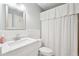 Bright bathroom with a white single sink vanity and marble countertop, toilet, and shower-tub combo at 918 Guinevere Way, Lilburn, GA 30047