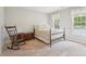 Cozy bedroom showcasing a rocking chair, complemented by two windows, offering serene views at 918 Guinevere Way, Lilburn, GA 30047