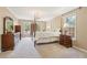 Traditional bedroom featuring a chandelier, four-poster bed, and two windows for natural light at 918 Guinevere Way, Lilburn, GA 30047