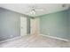 A blue bedroom with three doors, light carpet flooring, and a fan overhead at 918 Guinevere Way, Lilburn, GA 30047