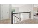 Upstairs hallway featuring a black and white banister, carpet flooring, and white walls at 918 Guinevere Way, Lilburn, GA 30047