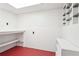 A well-lit white storage room with pegboard, shelves, and durable flooring at 918 Guinevere Way, Lilburn, GA 30047