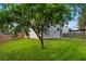 Backyard with a partial view of the home with fenced in yard and mature trees at 1389 Shadow Creek Ave, Hampton, GA 30228