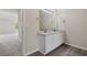 Bathroom featuring double sinks with granite counters, wood look flooring, and plenty of light at 1389 Shadow Creek Ave, Hampton, GA 30228