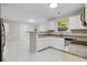 Open kitchen with granite countertops, white cabinets, and modern appliances at 1389 Shadow Creek Ave, Hampton, GA 30228