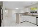 Bright kitchen features white cabinets, gray countertops, and stainless steel appliances at 1389 Shadow Creek Ave, Hampton, GA 30228