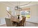 Bright dining room featuring a wooden table, modern light fixture, and a view of the front yard at 209 Crestmont Way, Canton, GA 30114