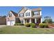 Two-story brick home with a covered porch, well-maintained lawn, and attached two-car garage offers curb appeal at 209 Crestmont Way, Canton, GA 30114