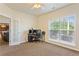Bright office space with a ceiling fan, computer setup and a glimpse into the adjacent kitchen at 209 Crestmont Way, Canton, GA 30114