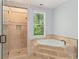 Bathroom featuring tiled walk-in shower and soaking tub with tiled step surround, and neutral tones at 335 Birkdale Dr, Fayetteville, GA 30215