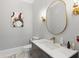 Modern powder room with a marble countertop, sleek mirror, and stylish lighting fixtures at 335 Birkdale Dr, Fayetteville, GA 30215
