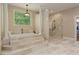 Elegant bathroom showcasing a luxurious soaking tub with steps and a separate glass-enclosed shower at 335 Birkdale Dr, Fayetteville, GA 30215