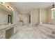 Large primary bathroom with a step-up soaking tub, dual vanity, and marble floors at 335 Birkdale Dr, Fayetteville, GA 30215