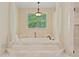 Bathroom featuring a soaking tub with steps below a window and an elegant chandelier at 335 Birkdale Dr, Fayetteville, GA 30215