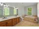 Bathroom featuring double sink vanity, soaking tub with tile surround, and window offering natural light at 335 Birkdale Dr, Fayetteville, GA 30215