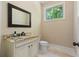 Well-lit powder room featuring granite countertops and a classic vanity at 335 Birkdale Dr, Fayetteville, GA 30215