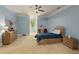 A carpeted bedroom with blue walls, crown molding, ceiling fan and a comfortable wooden bed frame at 335 Birkdale Dr, Fayetteville, GA 30215