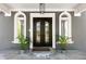 Close-up of an elegant front door flanked by decorative windows and lush potted plants at 335 Birkdale Dr, Fayetteville, GA 30215