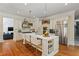 Elegant kitchen with white cabinetry, marble countertops, pendant lights, and stainless steel appliances at 335 Birkdale Dr, Fayetteville, GA 30215