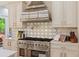 Close-up of a gourmet kitchen featuring a stainless steel range and a designer tile backsplash at 335 Birkdale Dr, Fayetteville, GA 30215
