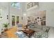 Bright living room boasts tall ceilings, hardwood floors, a comfortable sectional sofa, and a view into the kitchen at 335 Birkdale Dr, Fayetteville, GA 30215