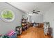 A home office with hardwood floors, round windows, ceiling fan and custom shelving for storage at 335 Birkdale Dr, Fayetteville, GA 30215