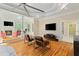 Sitting area with hardwood floors, a fireplace, tv, and sun-drenched skylights at 335 Birkdale Dr, Fayetteville, GA 30215