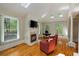 Sitting area with hardwood floors, a fireplace, tv, and sun-drenched skylights at 335 Birkdale Dr, Fayetteville, GA 30215
