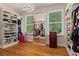 Organized walk-in closet with mirror sliding doors, shelving, and hardwood floors at 335 Birkdale Dr, Fayetteville, GA 30215
